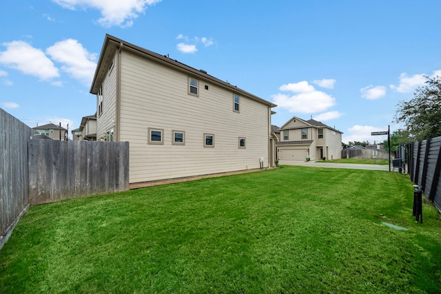 rear view of house featuring a garage and a lawn