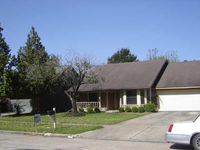 ranch-style home featuring covered porch, a garage, and a front lawn