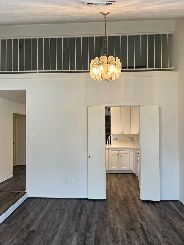 unfurnished dining area featuring dark hardwood / wood-style flooring and a chandelier