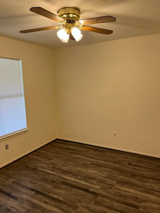 empty room with ceiling fan, dark hardwood / wood-style flooring, and a textured ceiling