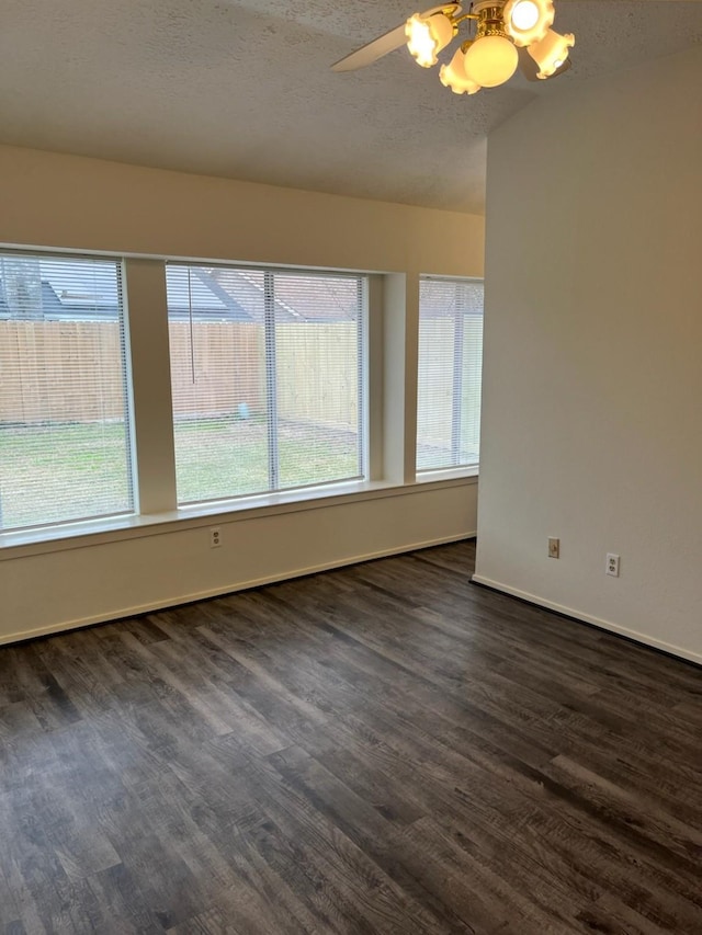 empty room featuring ceiling fan, dark hardwood / wood-style flooring, and a textured ceiling