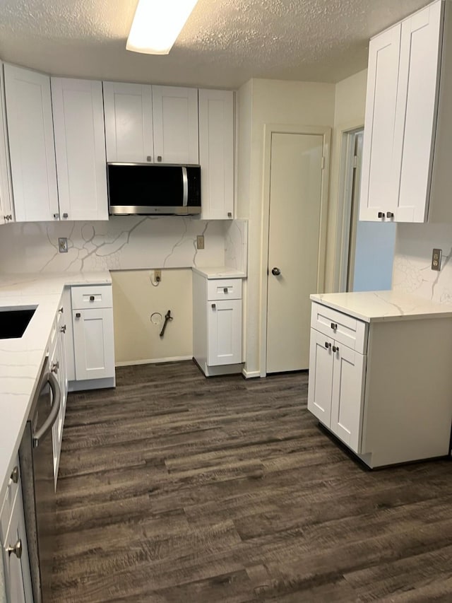 kitchen featuring white cabinets, a textured ceiling, dark hardwood / wood-style flooring, and tasteful backsplash