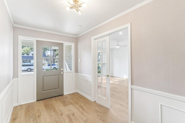 doorway featuring light wood-type flooring, crown molding, and an inviting chandelier