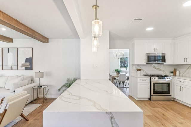 kitchen featuring stainless steel appliances, beam ceiling, decorative light fixtures, light hardwood / wood-style floors, and white cabinetry