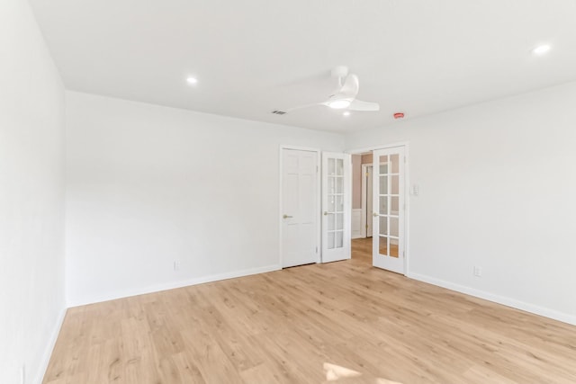 empty room with french doors, light wood-type flooring, and ceiling fan