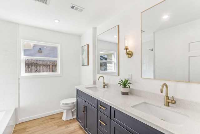 bathroom featuring hardwood / wood-style floors, plenty of natural light, toilet, and vanity