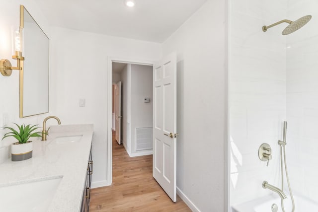 bathroom featuring hardwood / wood-style floors, vanity, and bathtub / shower combination