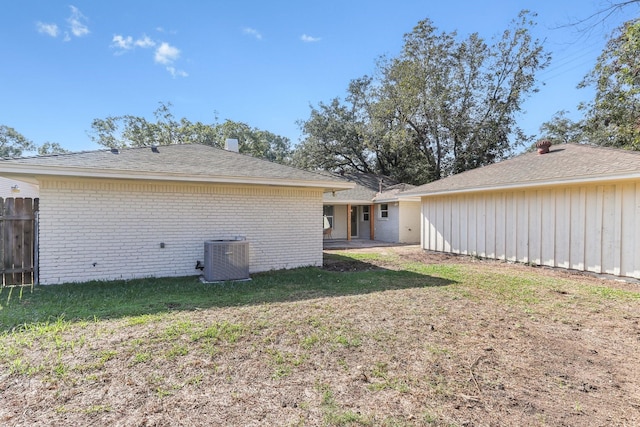 back of house featuring a lawn, cooling unit, and a patio