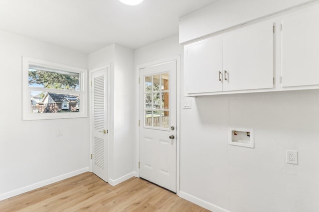 clothes washing area featuring light hardwood / wood-style flooring, cabinets, and washer hookup