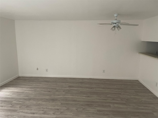 empty room with ceiling fan and dark wood-type flooring