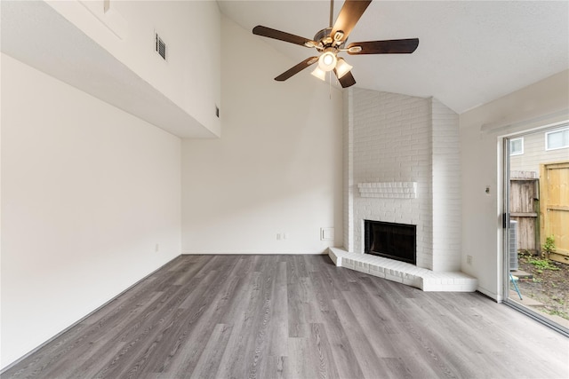 unfurnished living room featuring ceiling fan, a fireplace, high vaulted ceiling, and light hardwood / wood-style flooring