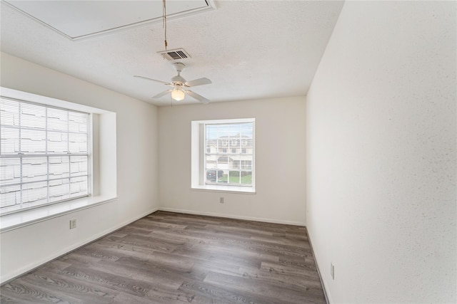 spare room with ceiling fan, a textured ceiling, and hardwood / wood-style flooring