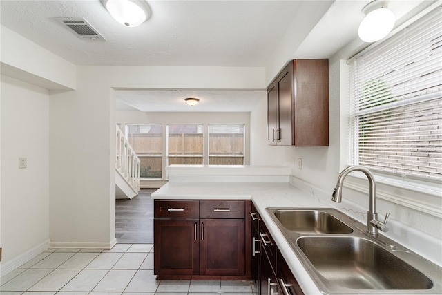 kitchen with sink, light tile patterned flooring, and a textured ceiling