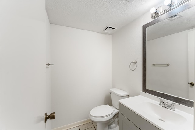 bathroom featuring tile patterned flooring, vanity, a textured ceiling, and toilet