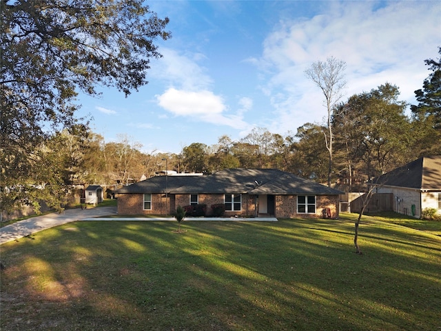 ranch-style home featuring a front lawn and brick siding