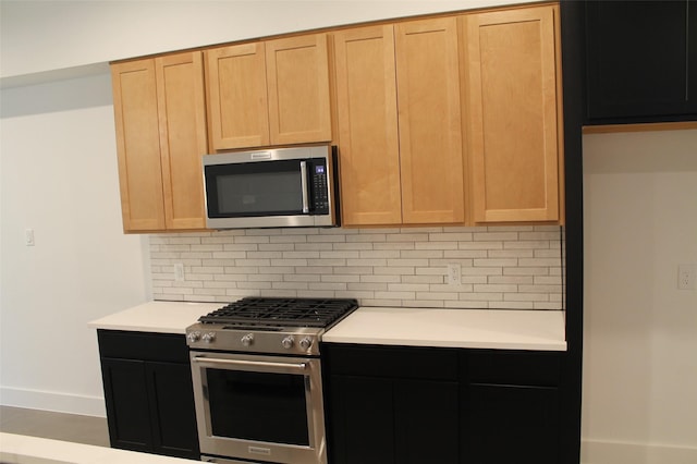 kitchen with light brown cabinetry, backsplash, and stainless steel appliances