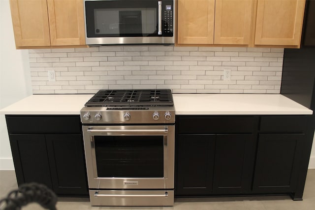 kitchen featuring stainless steel appliances, light brown cabinetry, and tasteful backsplash