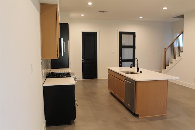 kitchen featuring decorative backsplash, dishwasher, a center island with sink, and sink