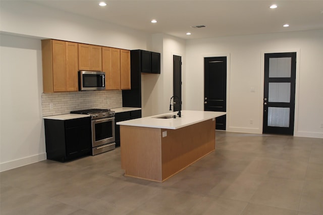 kitchen featuring backsplash, stainless steel appliances, a kitchen island with sink, and sink