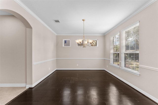 empty room with crown molding, hardwood / wood-style floors, and a notable chandelier