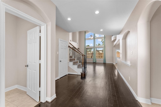 foyer entrance with wood-type flooring, ceiling fan, and vaulted ceiling