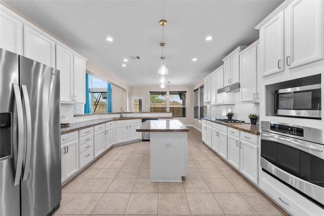 kitchen with sink, white cabinets, hanging light fixtures, a center island, and stainless steel appliances