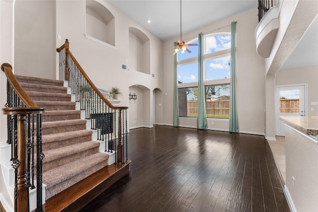 entryway with a high ceiling, hardwood / wood-style floors, and ceiling fan