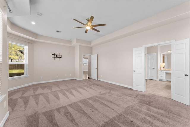 carpeted empty room featuring ceiling fan and a tray ceiling