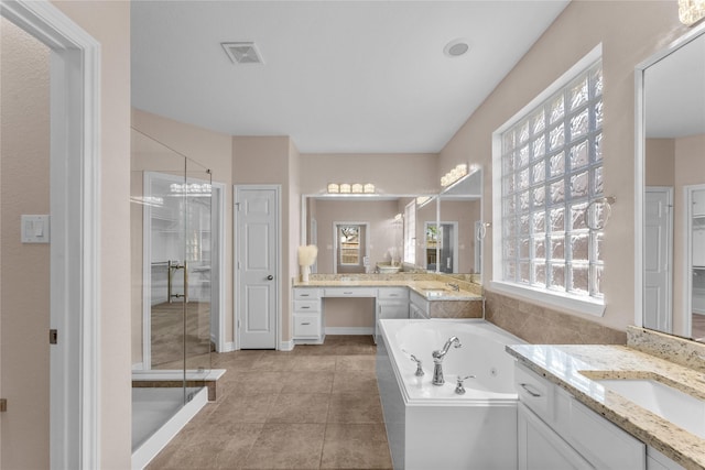 bathroom featuring independent shower and bath, vanity, and tile patterned flooring