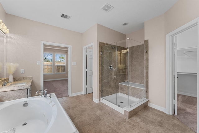 bathroom with vanity, tile patterned flooring, and plus walk in shower