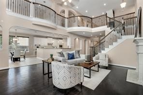 living room featuring dark wood-type flooring and a towering ceiling