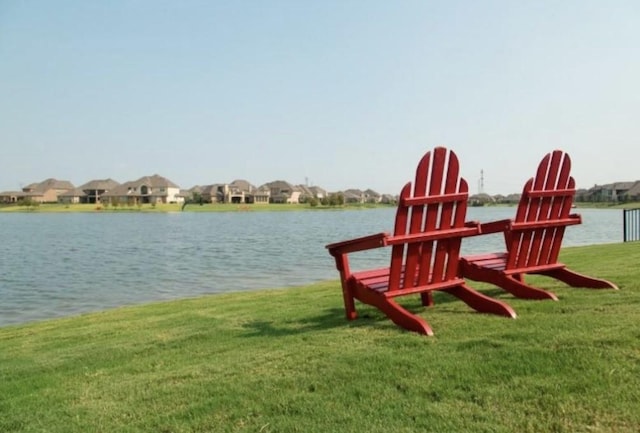 exterior space featuring a lawn and a water view