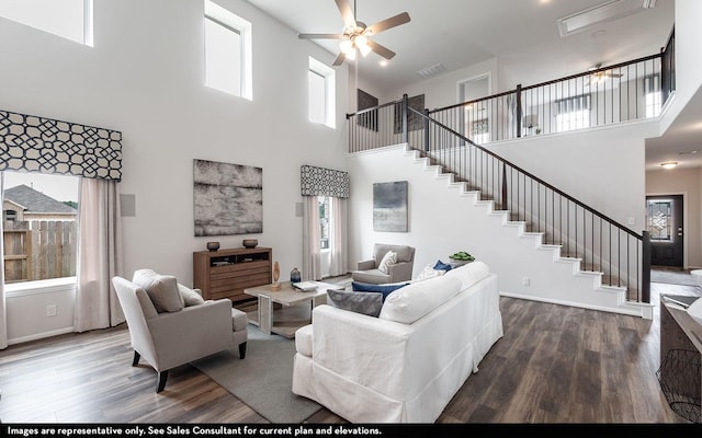 living room featuring a wealth of natural light, a towering ceiling, and wood-type flooring