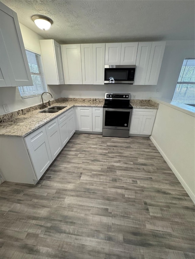 kitchen featuring plenty of natural light, sink, white cabinetry, and stainless steel appliances