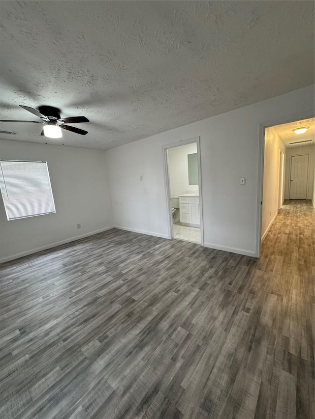 unfurnished room featuring a textured ceiling, ceiling fan, and dark hardwood / wood-style floors