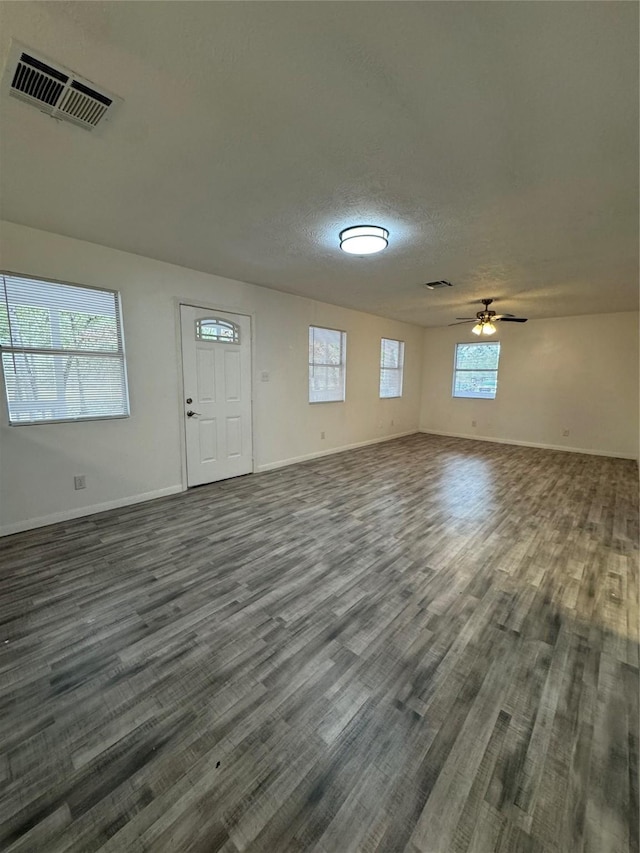 interior space featuring ceiling fan, dark hardwood / wood-style flooring, and a textured ceiling