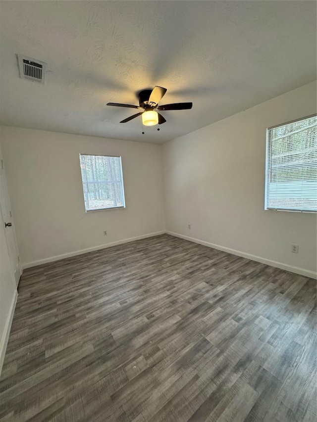 spare room with dark hardwood / wood-style flooring, plenty of natural light, and ceiling fan