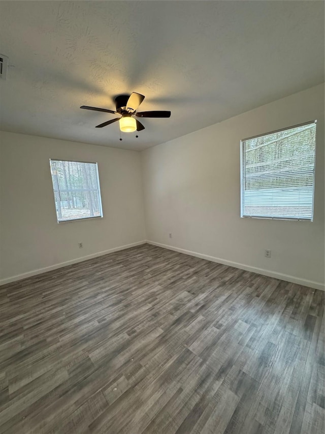 spare room with dark hardwood / wood-style floors and ceiling fan