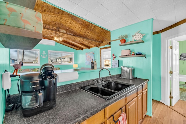 kitchen featuring a wall unit AC, plenty of natural light, light hardwood / wood-style flooring, and sink