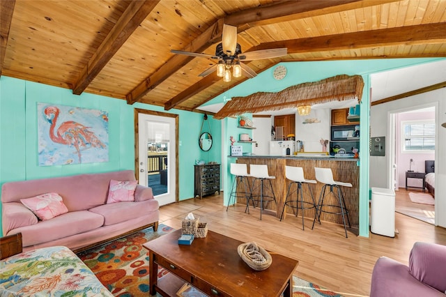 living room featuring vaulted ceiling with beams, ceiling fan, light wood-type flooring, and wooden ceiling