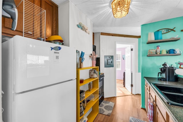 kitchen featuring white refrigerator, sink, and light hardwood / wood-style flooring