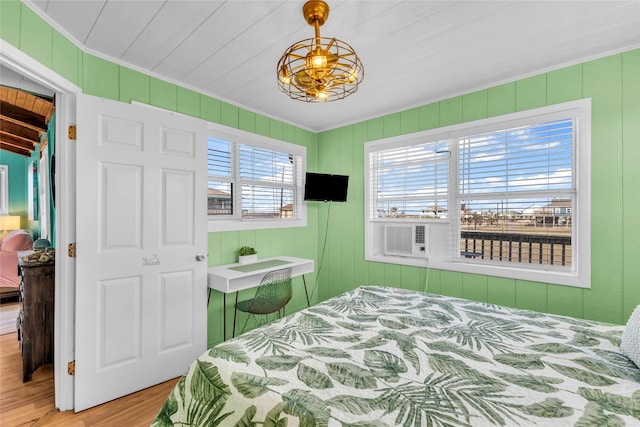 bedroom featuring wooden walls, hardwood / wood-style floors, and cooling unit