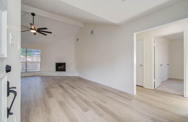 unfurnished living room featuring vaulted ceiling with beams, ceiling fan, a fireplace, and light hardwood / wood-style floors