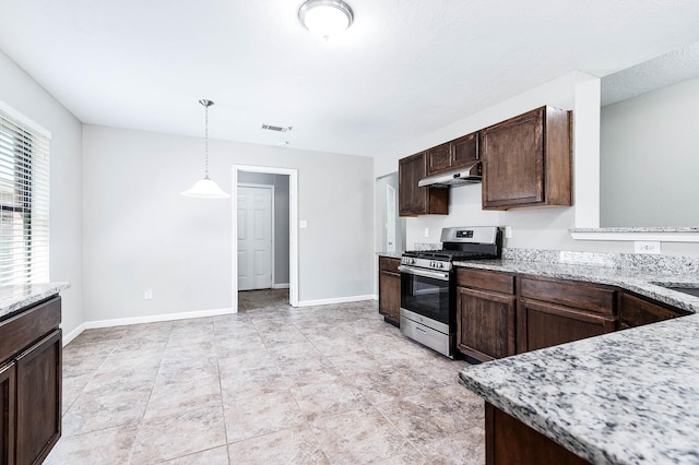 kitchen with stainless steel gas range oven, light stone counters, dark brown cabinets, and decorative light fixtures