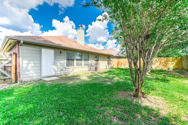 rear view of property featuring a yard