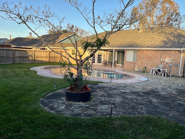 view of pool with french doors, a patio area, and a lawn