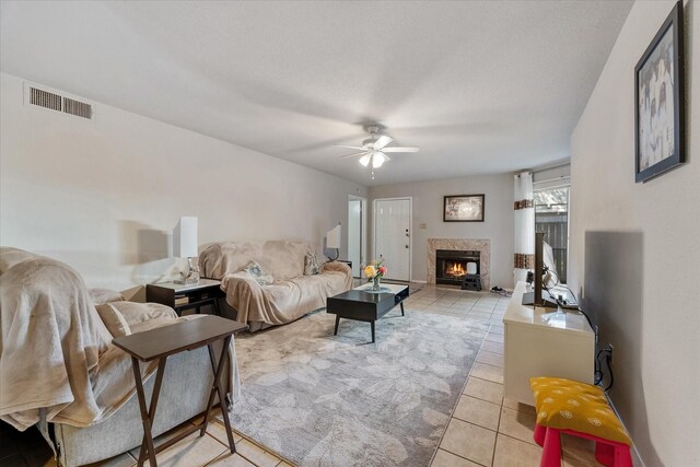 tiled living room featuring ceiling fan and a textured ceiling