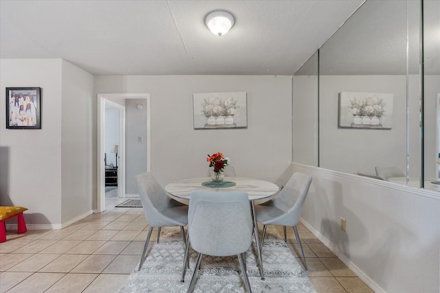 dining room featuring a textured ceiling and light tile patterned flooring