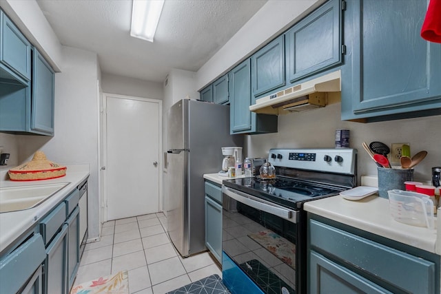 kitchen featuring a textured ceiling, sink, light tile patterned floors, and stainless steel appliances