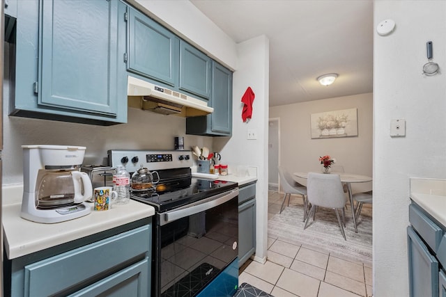 kitchen featuring blue cabinets, stainless steel range with electric cooktop, and light tile patterned flooring